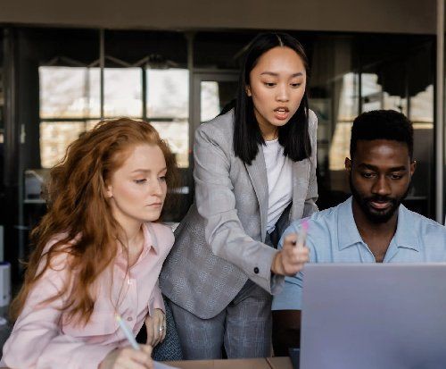 A group collaborating around a laptop.
